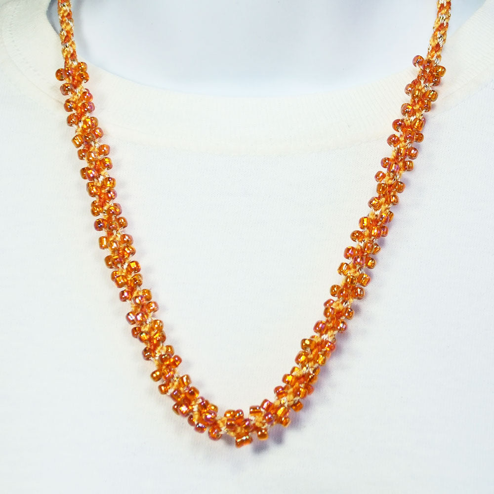 8120  *Peachy Orange beaded Kumihimo braided single strand necklace.    *Size:  22 inch length around the neck.   *Brass cones & toggle clasp.