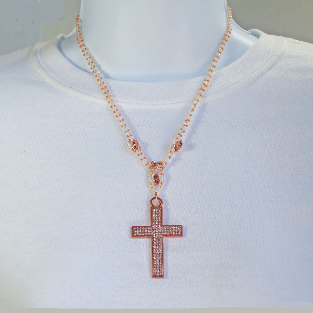 Cross in copper metal designed in fave crystals.  Clear seed bead and Czech Glass beads in Apricot color suing netting stitch for neckwear.  