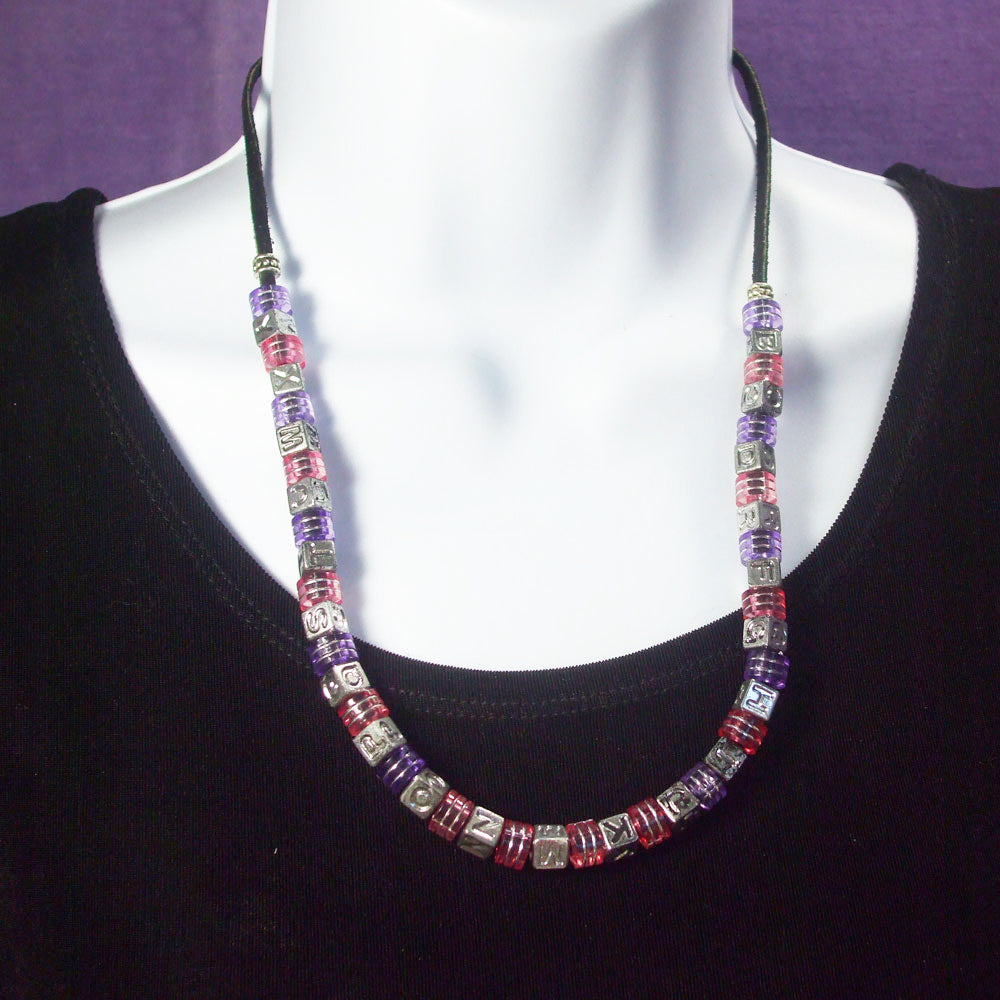 *Various square silver alpha beads altered with square color designed beads on black leather cord.  Hook & Eye clasp.