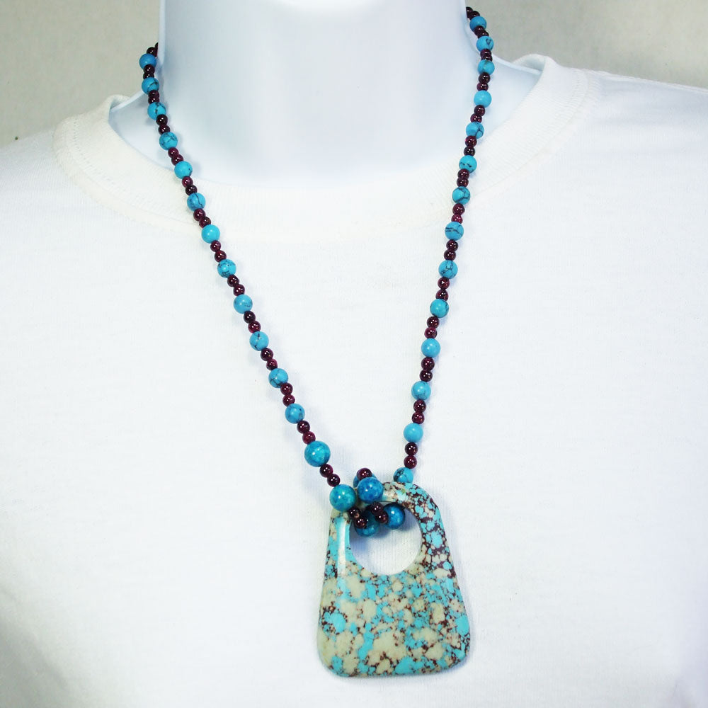 7489-Turquoise and Pyrite mixed minerals in donut shaped pendant.   Turquoise and garnet mineral beads make the neckwear.