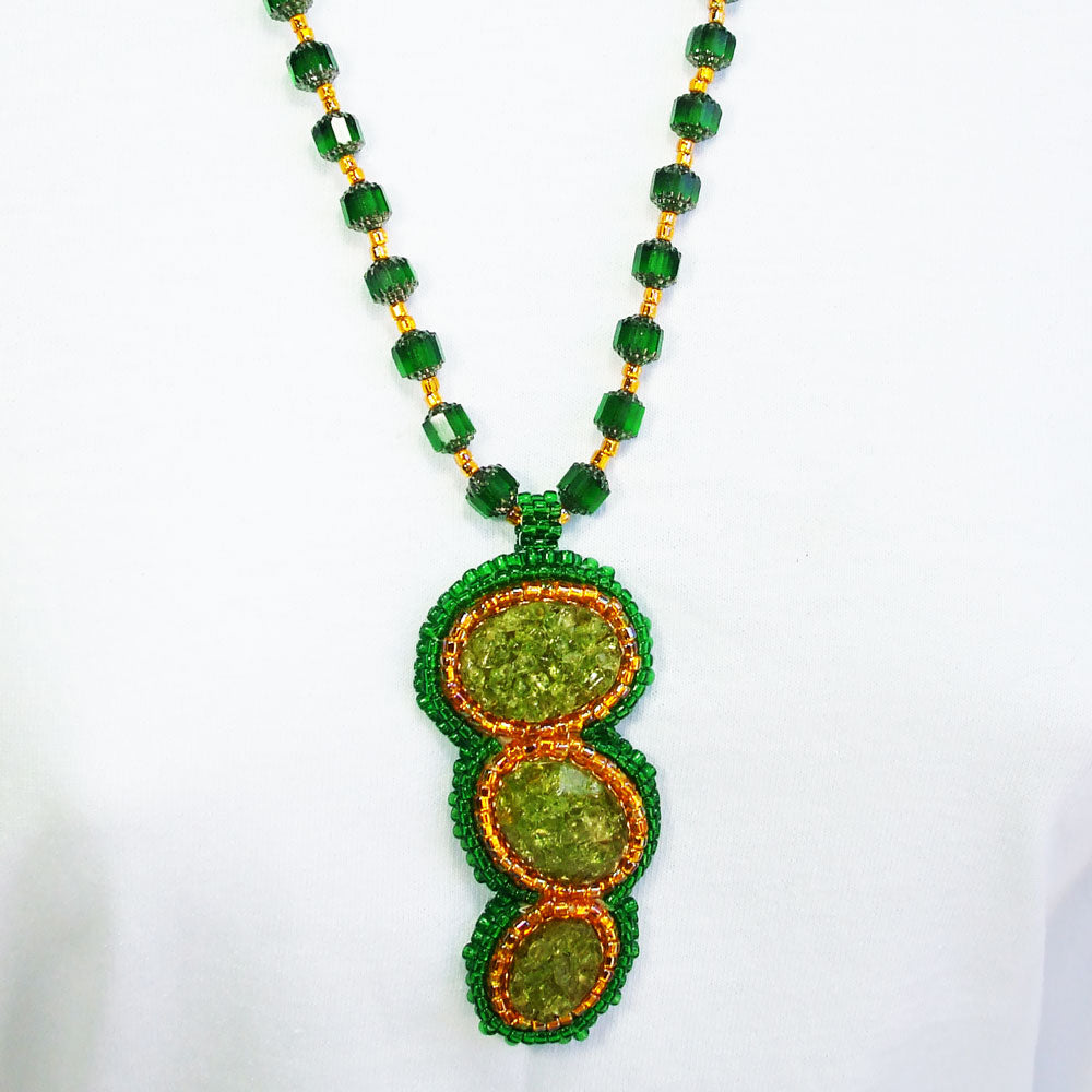 7491-Green crushed glass cabochon, gold and green bezel. Green glass beads with gold seed bead accent for neckwear.