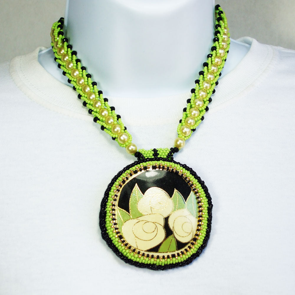 7494-Cabochon painted with three roses in cream & black.  *Pearl & green seed beaded spiral neckwear accent in black.