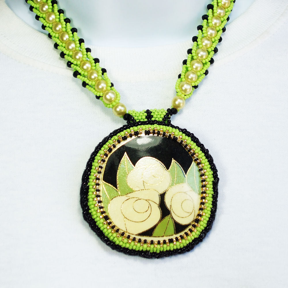 7494-Cabochon painted with three roses in cream & black.  *Pearl & green seed beaded spiral neckwear accent in black.
