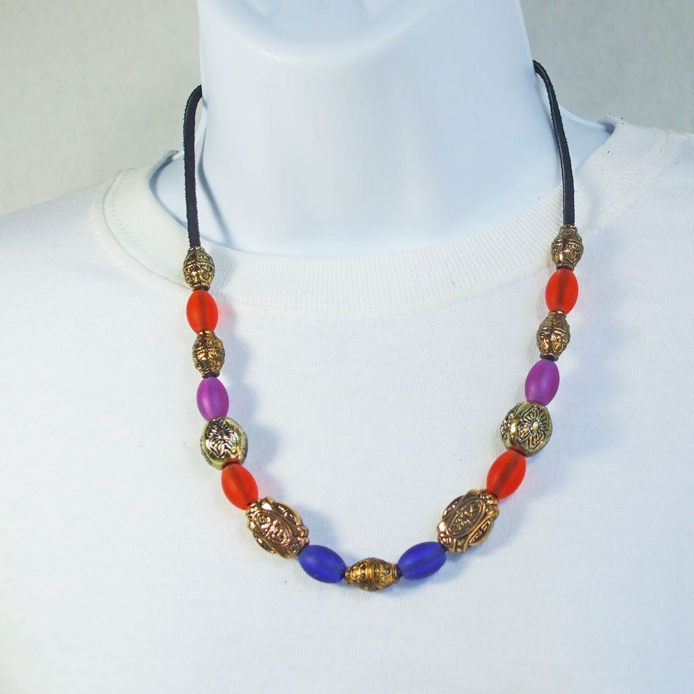 7536 *Single Black Leather cord with orange, purple, blue colored glass beads. *Silver and gold tone accent beads.  Copper toggle clasp.