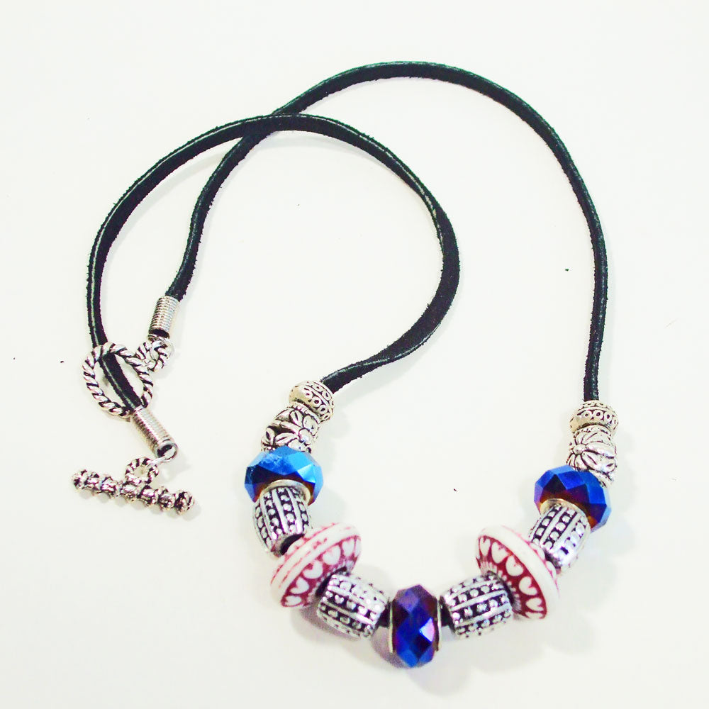 7544 *Blue designer bead with blue glass, silver and red ceramic beads. *Black leather single strand leather.  Silver toggle clasp.
