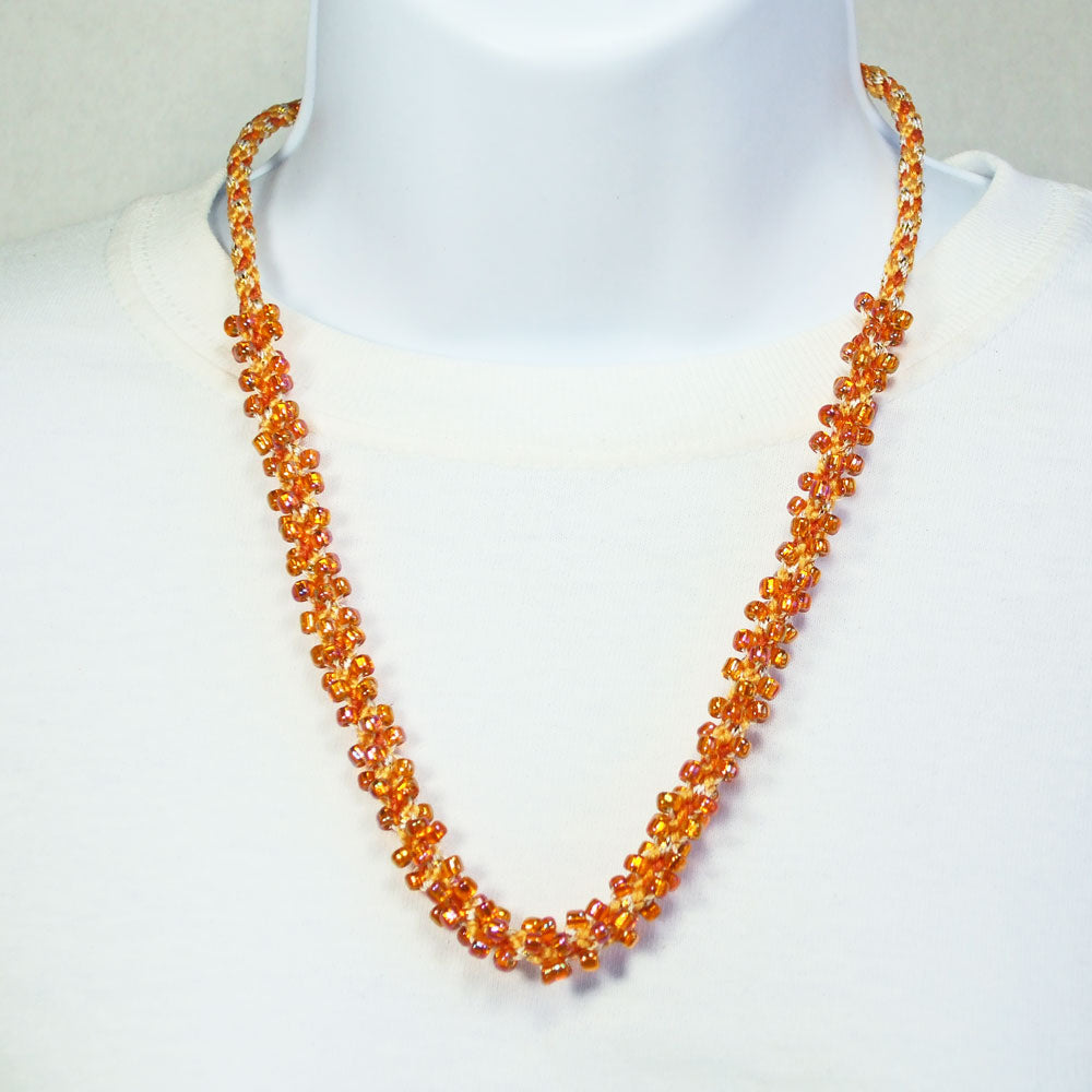 8120  *Peachy Orange beaded Kumihimo braided single strand necklace.    *Size:  22 inch length around the neck.   *Brass cones & toggle clasp.