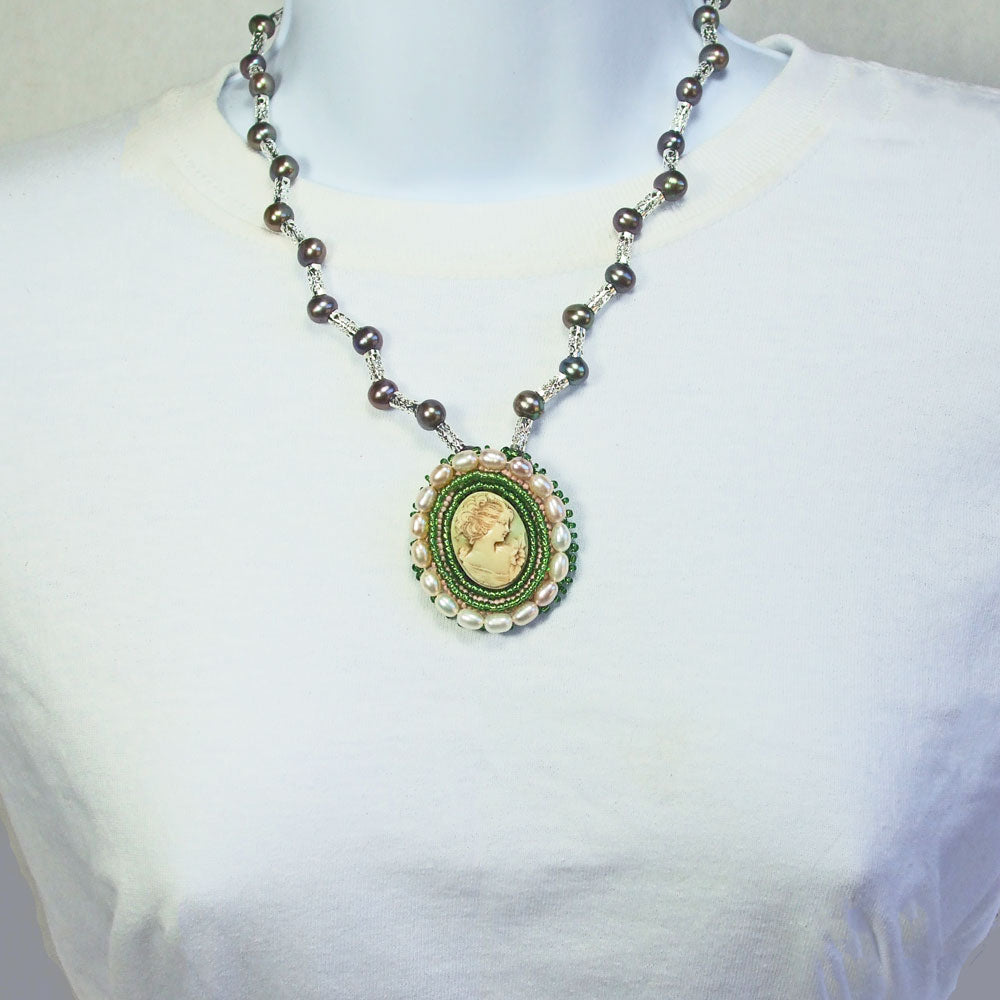 8122  *Multi colored, cultured Fresh H2/0 pearls and silver accent beads necklace. *17 potatoe pearls bezel around lady cameo in pale green. *28 beautiful multi colored cultured pearls in a single strand.